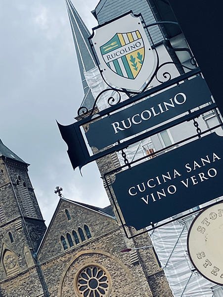 Image, L'avant du bâtiment avec l'accent sur les enseignes du restaurant Rucolino en arrière-plan la cerise de Dudelange.